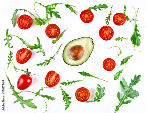 Halved avocado and tomatoes with rucola leaves isolated on a white background. Top view.