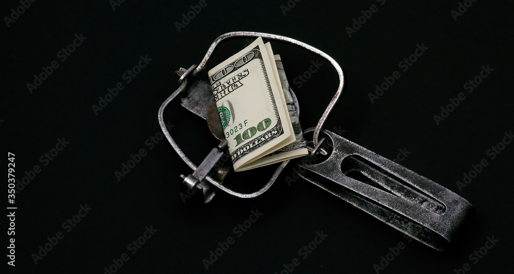 Trap with a bait of money dollars banknotes on a black background. Concept Trap with a bait of money dollars banknotes on a black background. Concept