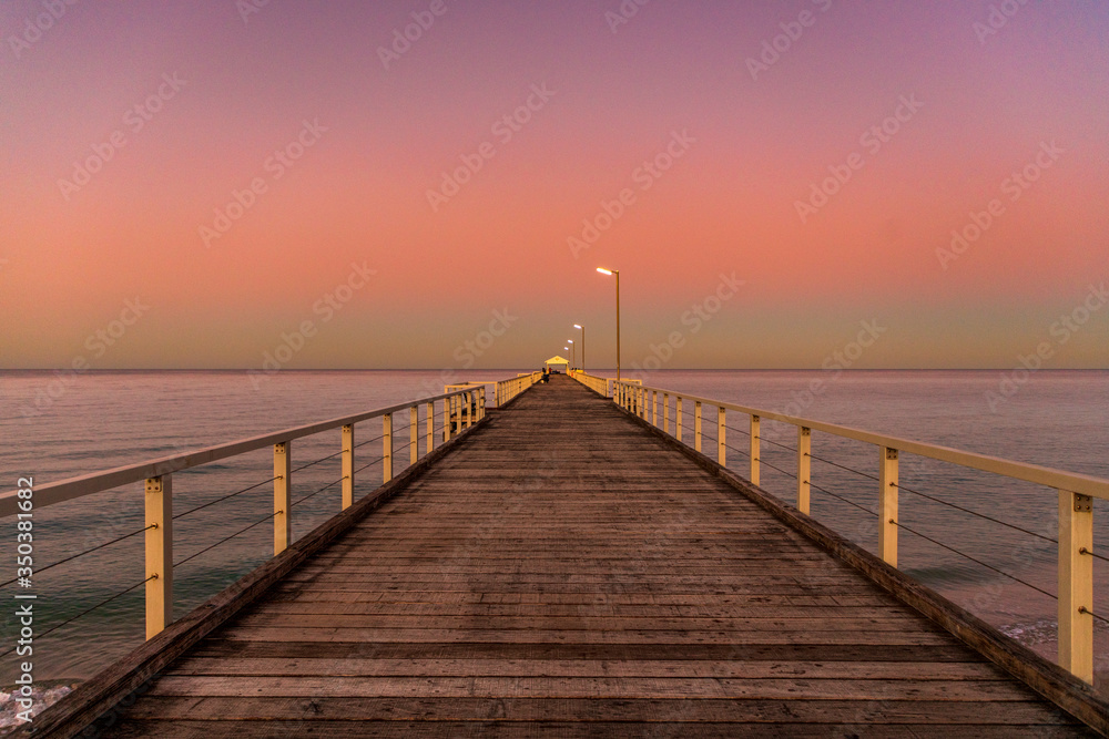 pier at sunset over beach