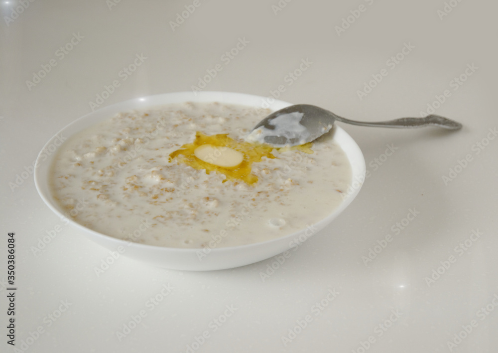 oatmeal with a slice of butter on a white table in the morning oatmeal with a slice of butter on a white table in the morning