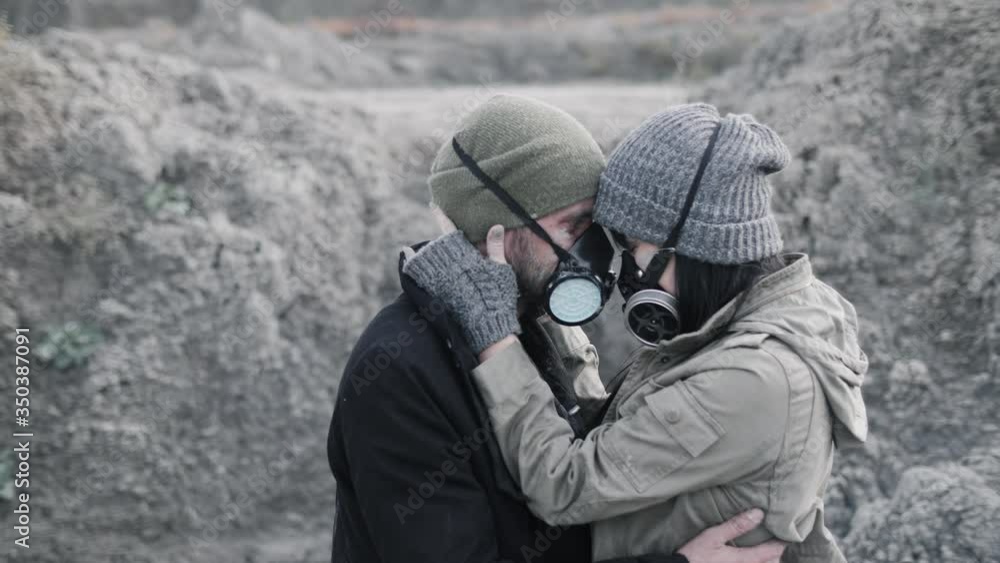 A survivor lovely couple in gas mask hugging on desolate out forest landscape. A survivor lovely couple in gas mask hugging on desolate out forest landscape.