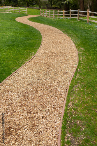 Foreground focus on a curved wood chip path in a garden
