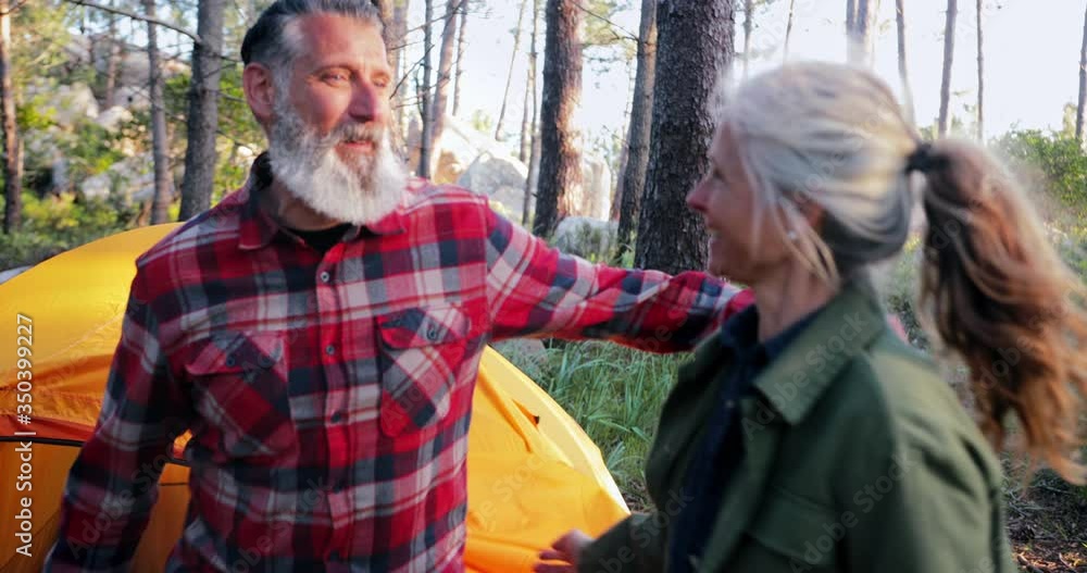 Close up senior couple getting out of tent in forest Close up senior couple getting out of tent in forest