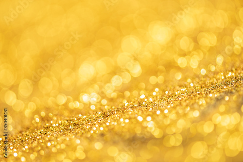 Gold glitter texture. Sparkling gold bright bokeh from blurred diamond dust. Abstract golden bokeh background. Selective focused