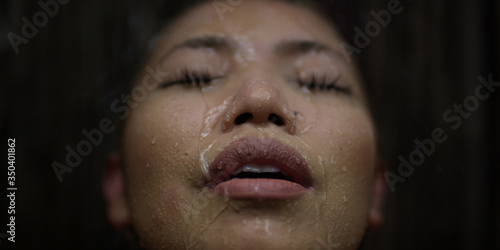 Woman closes her eyes letting water wash over her while taking a shower outdoors in a unique spa experience