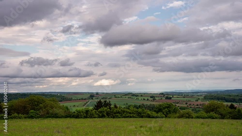 Time-lapse of clouds moving across the fields in different directions and heights