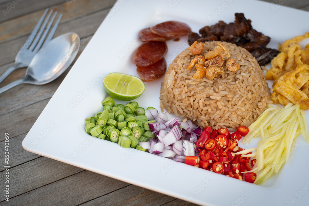 Thai food - Kao Cluk Ka Pi (Mixed Cooked Rice with Shrimp Paste Sauce) on white round dish. Fried rice with Shrimp paste, Thai style food. Thailand's national dishes. - obrazy, fototapety, plakaty 