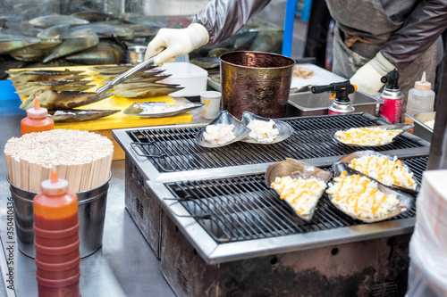 Flame of scallops ~ A kind of street snack Korean food style at Myeong-dong street food, Seoul, South Korea photo