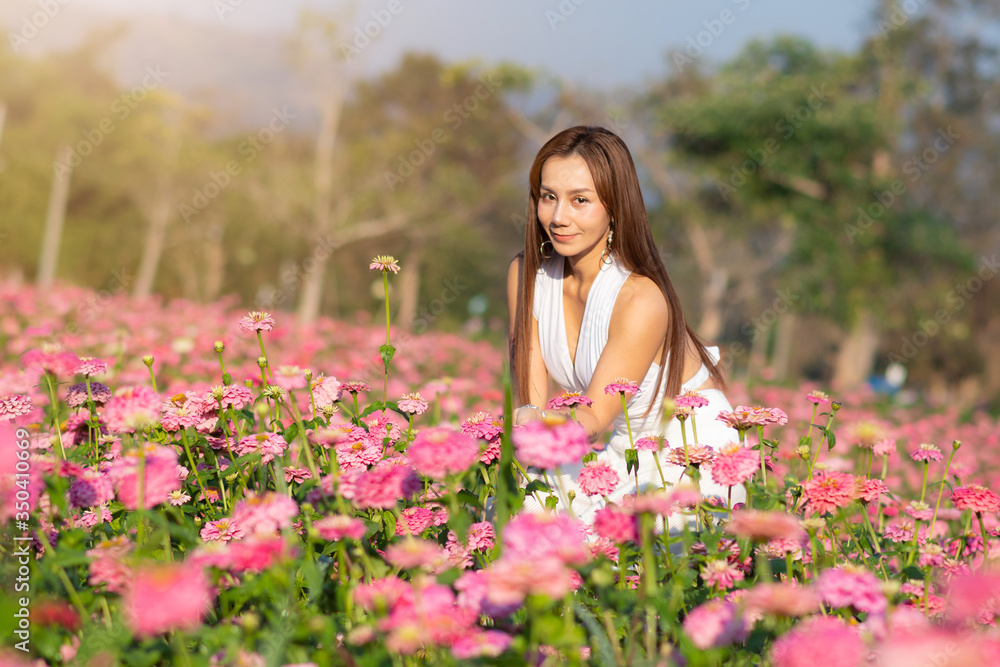 happy young woman enjoying summer in zinnia field. Beautiful woman relaxing in pink flower garden. happy young woman enjoying summer in zinnia field. Beautiful woman relaxing in pink flower garden.