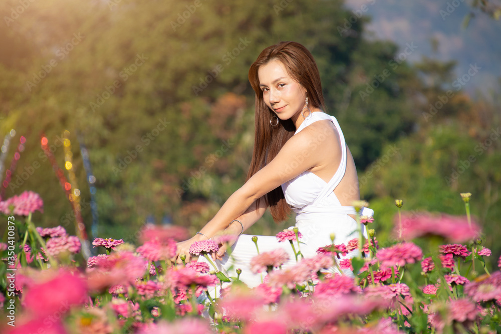 happy young woman enjoying summer in zinnia field. Beautiful woman relaxing in pink flower garden. happy young woman enjoying summer in zinnia field. Beautiful woman relaxing in pink flower garden.