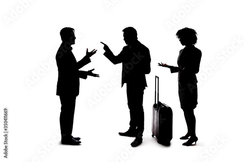Silhouette of a group of unrecognizable people crowded together ignoring social distancing and talking to each other and socializing.  They are co-workers networking or friends hanging out
