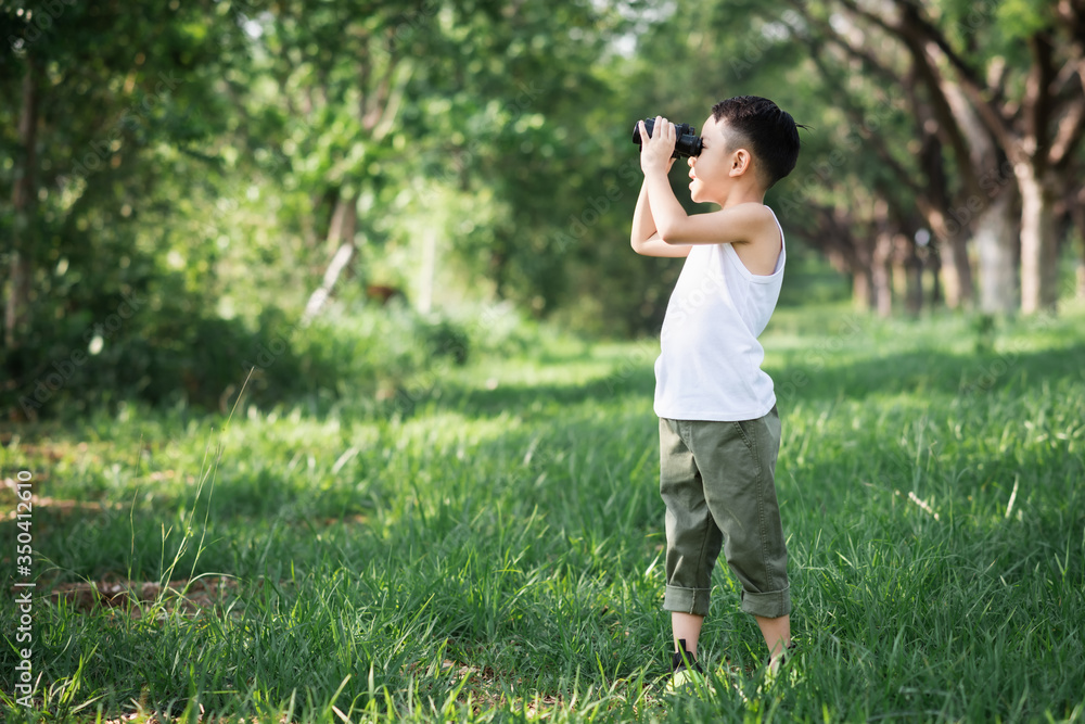 little boy use binoculars in summer garden on warm day outdoors.. little boy use binoculars in summer garden on warm day outdoors..