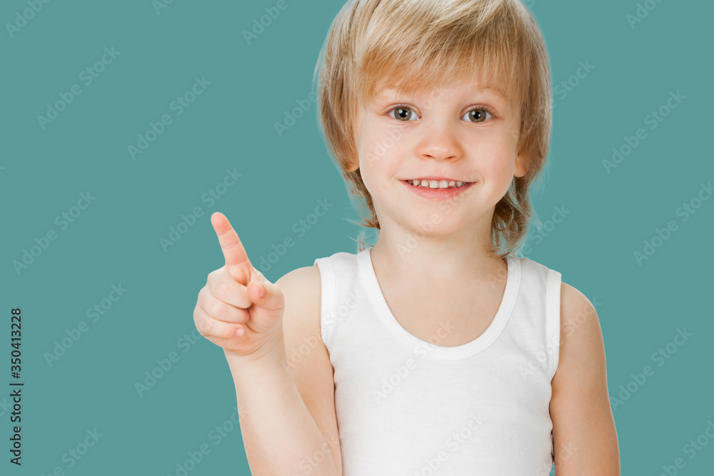 Happy little boy gesturing with finger and showing direction Happy little boy gesturing with finger and showing direction