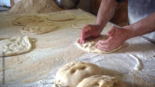 Baker male rolling out dough to make traditional Ramadan bread