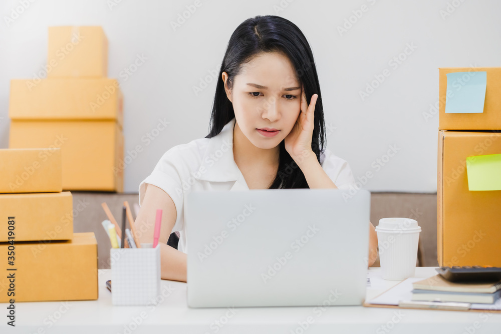 Asian beautiful young businesswoman feeling headache and stress in office space background with product box.Concept of Healthcare and Office syndrome. Asian beautiful young businesswoman feeling headache and stress in office space background with product box.Concept of Healthcare and Office syndrome.