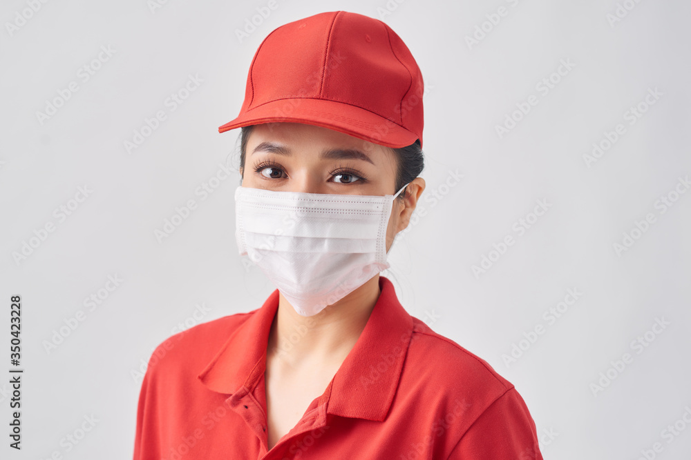 Young delivery woman wearing mask protect covid-19 over white isolated background. Work from home and delivery concept Young delivery woman wearing mask protect covid-19 over white isolated background. Work from home and delivery concept