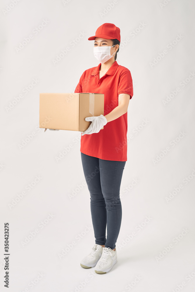 Delivery woman holding cardboard boxes in medical rubber gloves and mask on white background. Delivery woman holding cardboard boxes in medical rubber gloves and mask on white background.