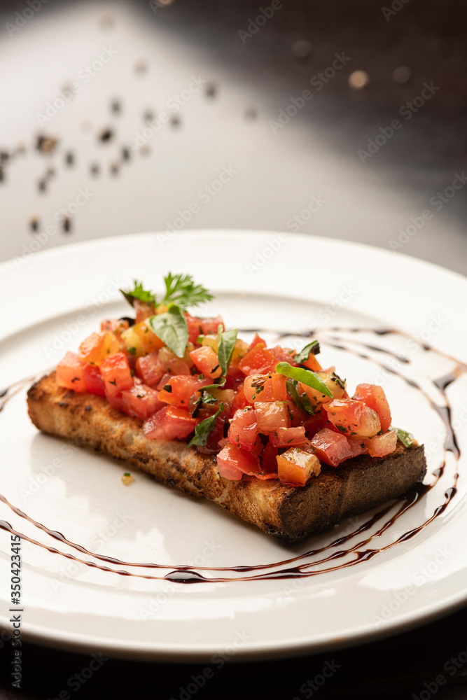 tomato bruschetta with basil and parsley on white plate tomato bruschetta with basil and parsley on white plate