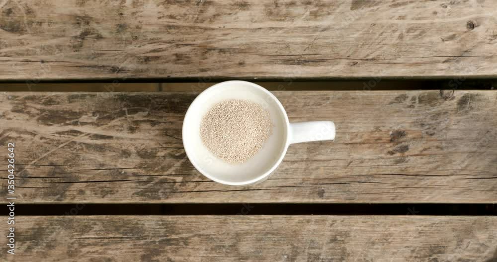 Putting yeast in a mug of milk Putting yeast in a mug of milk