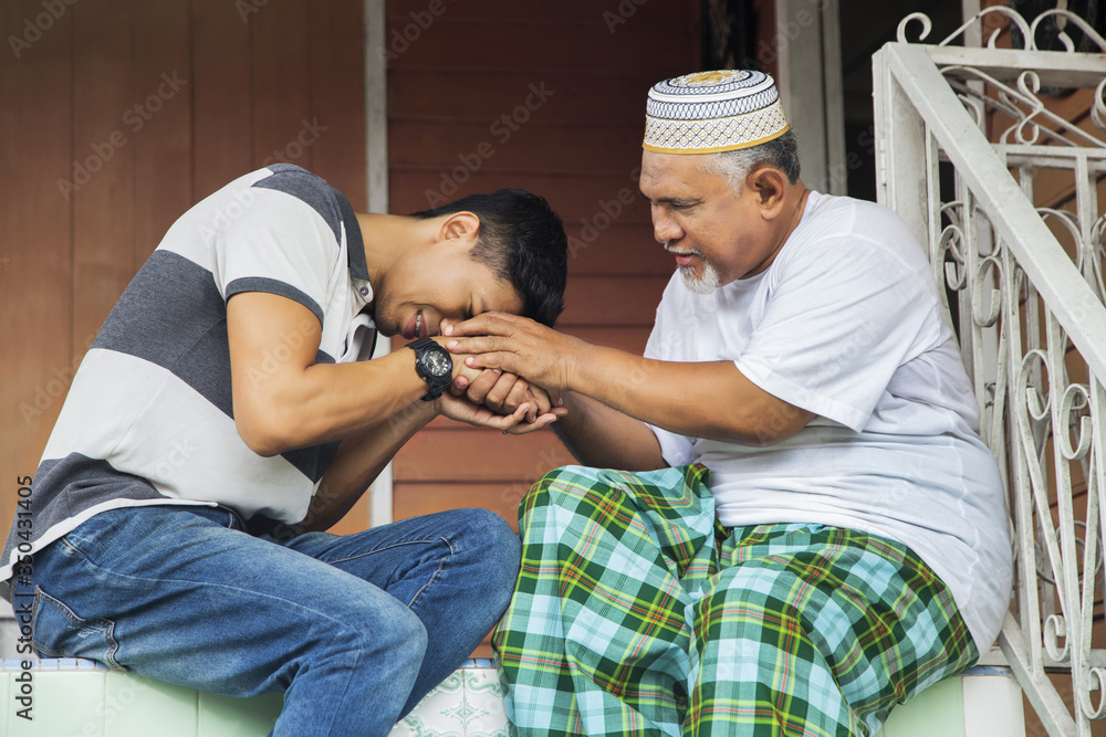 Man greeting his father with handshake Man greeting his father with handshake