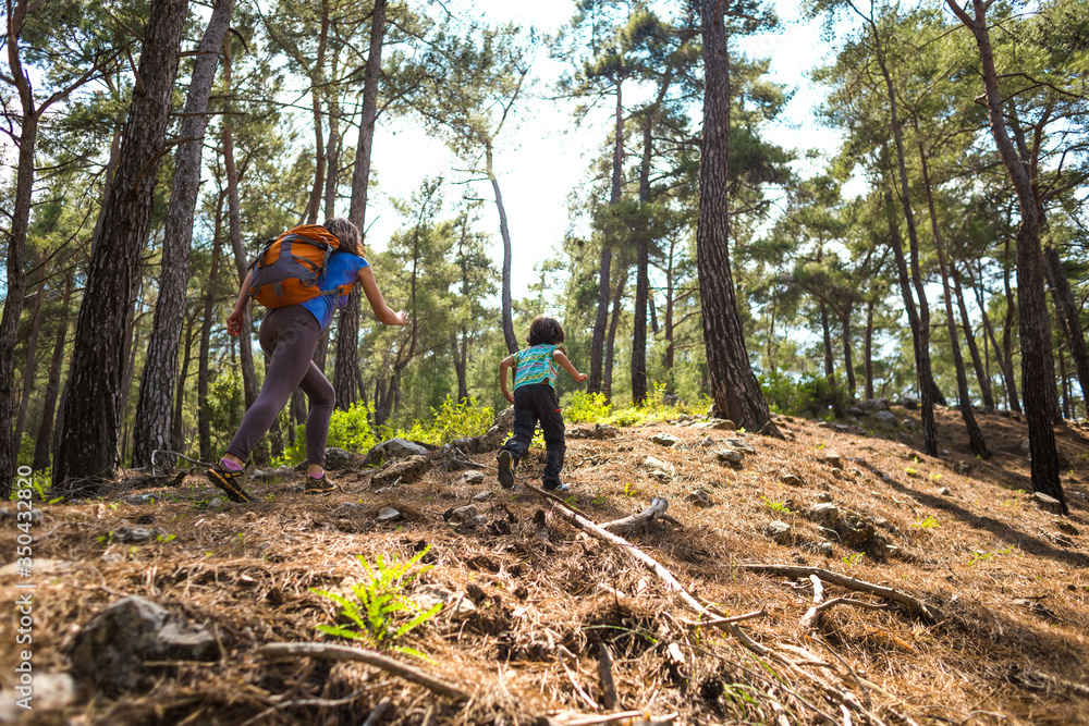 A woman runs with a child on a forest road. A woman runs with a child on a forest road.