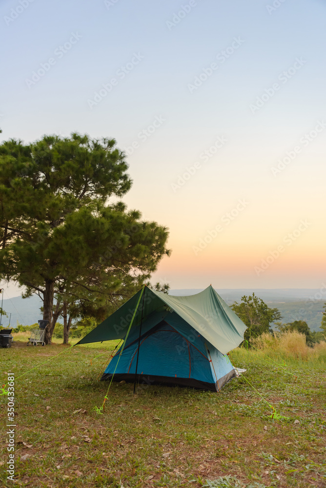 Tourist tent on among meadow in the sunset overlooking mountains. outdoors camping