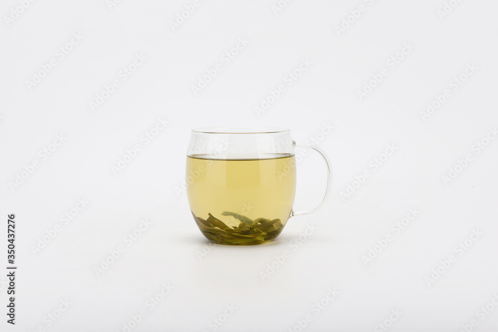The tea is isolated in a transparent glass against a white background The tea is isolated in a transparent glass against a white background