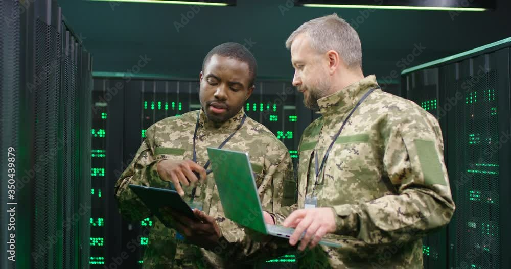 Multiethnic male army officers with tablet device and laptop computer ...