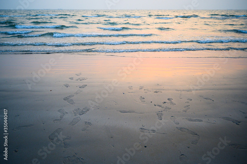 Soft wave with blue ocean on sandy beach.