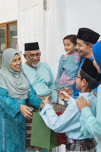 Muslim family visiting senior couple on Eid al-Fitr