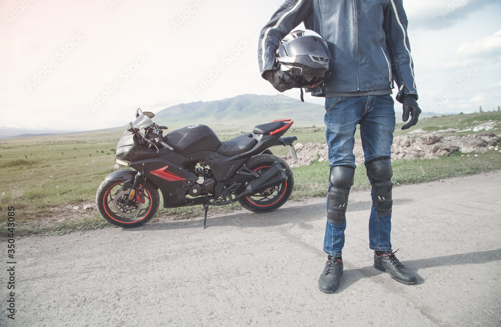 Caucasian biker holding helmet. Hobby. Sport. Speed Caucasian biker holding helmet. Hobby. Sport. Speed