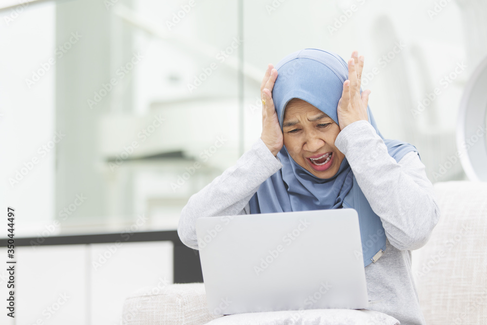Senior woman is shocked looking at laptop screen Senior woman is shocked looking at laptop screen