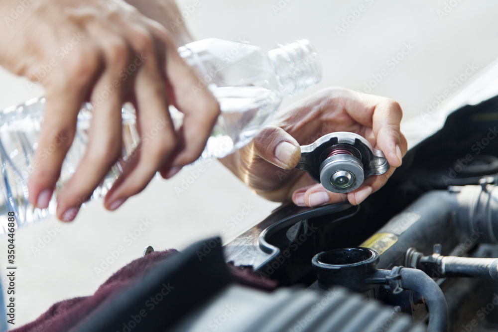 Man adding water to car radiator