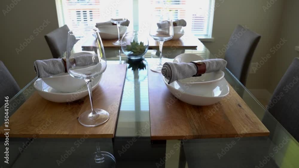 Dinner Table Nicely Arranged with Plates, Cutlery, and Wine Glasses Dinner Table Nicely Arranged with Plates, Cutlery, and Wine Glasses