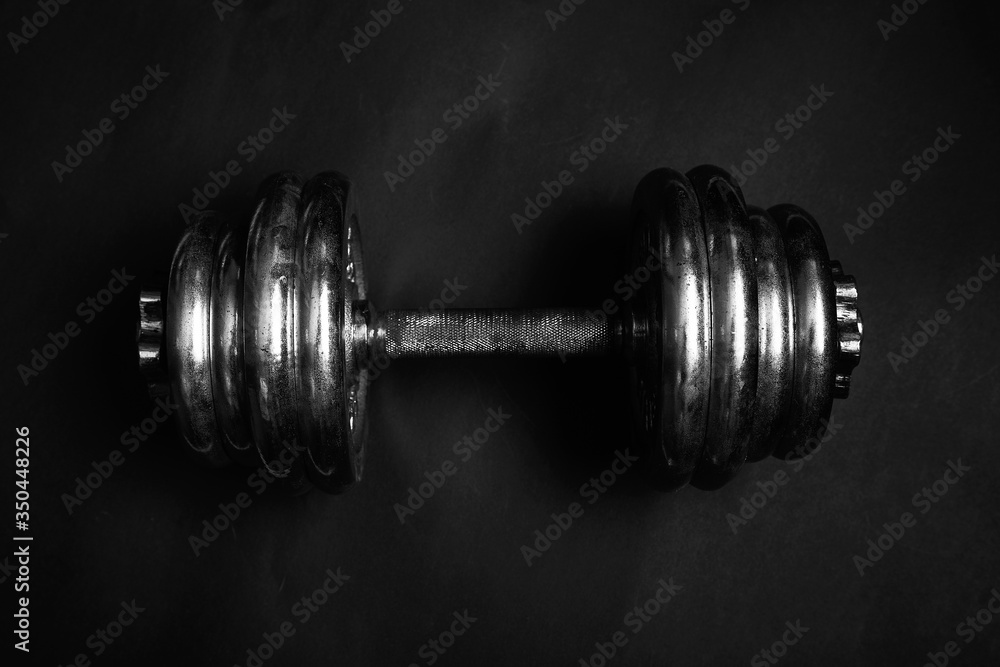 Dramatic black and white photo of dumbbells from above 