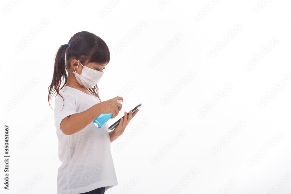 Asian girl wear mask cleaning smartphone screen with alcohol.on white background. Concept of Cleaning dirty screen phone for disease prevention from bacteria. Asian girl wear mask cleaning smartphone screen with alcohol.on white background. Concept of Cleaning dirty screen phone for disease prevention from bacteria.