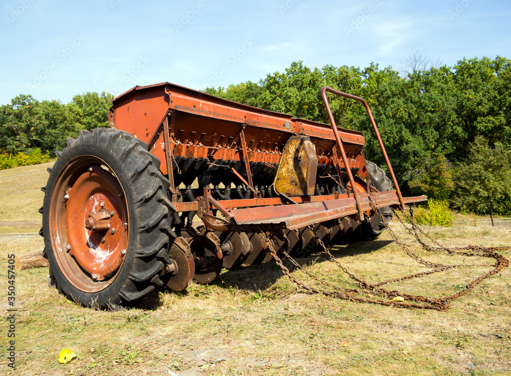 Grain seeder stands on the edge of the field Grain seeder stands on the edge of the field