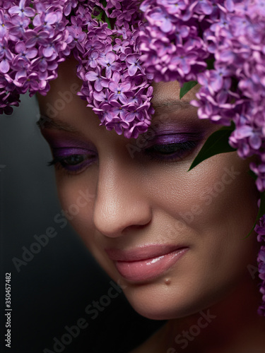 Beauty woman close up in Lilac in blossom. Lilac make up portrait. Beauty lady face close up