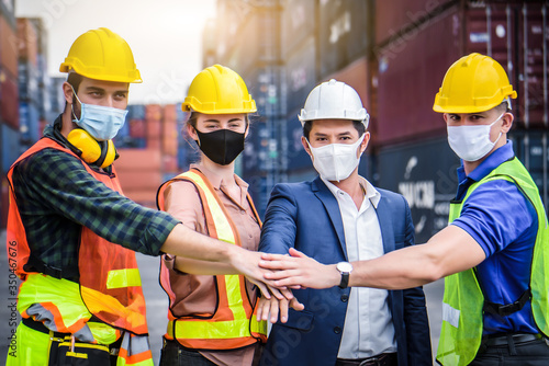 Engineer team people standing with their hands together at the container yard and check for control loading Containers box from Cargo freight ship for import and export. Team Teamwork Concept