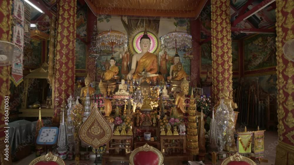 Statues on altar amidst pattern over columns in Buddhist temple - Chiang Rai, Thailand Statues on altar amidst pattern over columns in Buddhist temple - Chiang Rai, Thailand