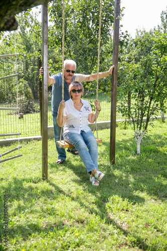 portrait of happy of middle aged couple on a green grass © fasli