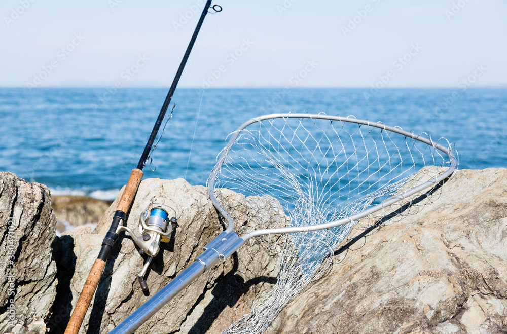 Fototapeta premium Spinning and fishing net on the rocks