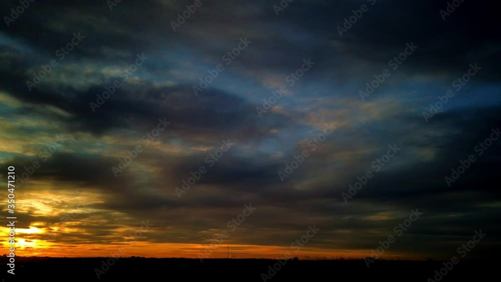 Incredible fire sunrise time lapse with dark cloud before the rain storm with red, orange, purple, amber light Incredible fire sunrise time lapse with dark cloud before the rain storm with red, orange, purple, amber light