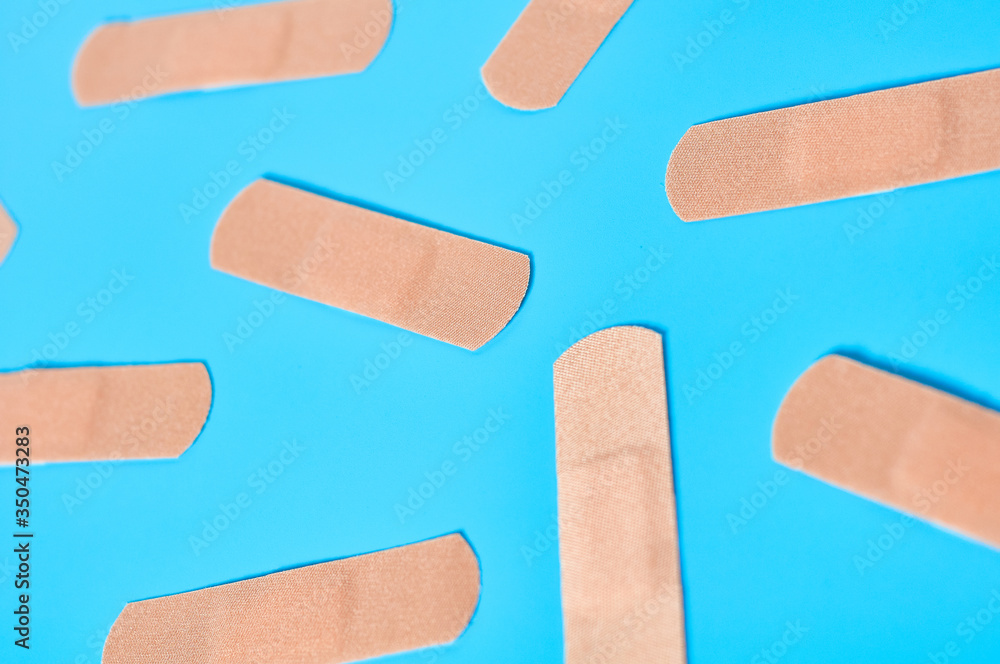 Scattered sticky medical patches on blue background. Healthcare concept Scattered sticky medical patches on blue background. Healthcare concept