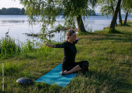horizontal photo of a young woman doing yoga outdoors