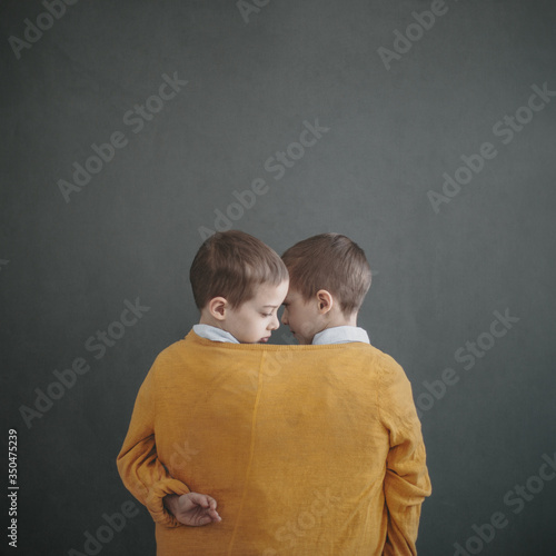 Twin boys by the wall