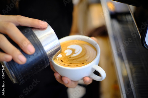 Barista making a cup of coffee latte art.