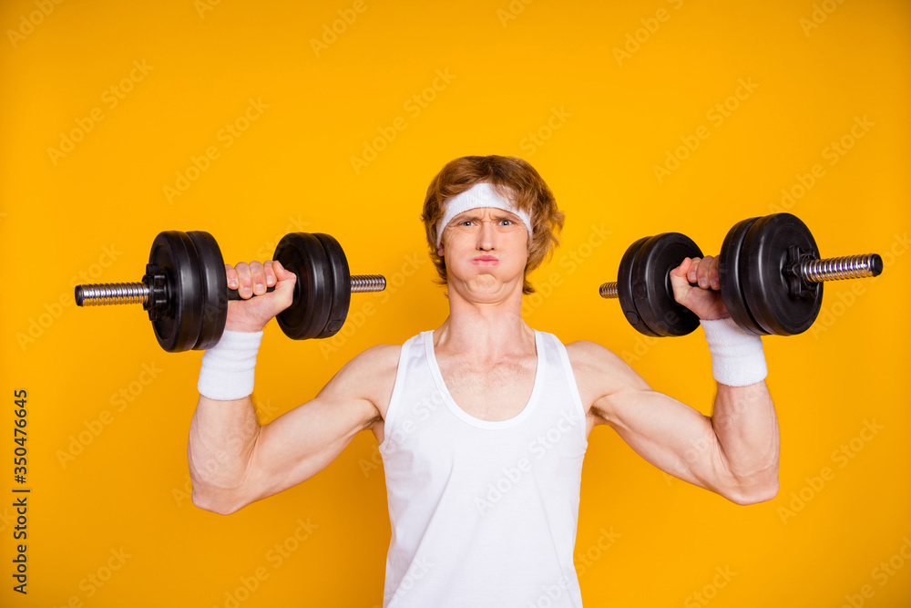 Close-up portrait of his he nice attractive sportive funky motivated guy sportsman lifting heavy barbell doing work out fat burn isolated over bright vivid shine vibrant yellow color background Close-up portrait of his he nice attractive sportive funky motivated guy sportsman lifting heavy barbell doing work out fat burn isolated over bright vivid shine vibrant yellow color background