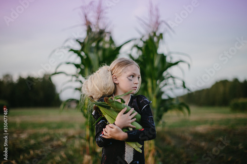Portrait of girl holding corns in field