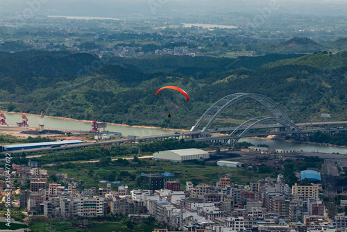 Outdoor city green hill scenery and paragliding